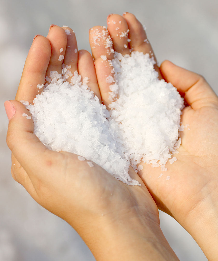 A woman holding a handful of dead sea salt