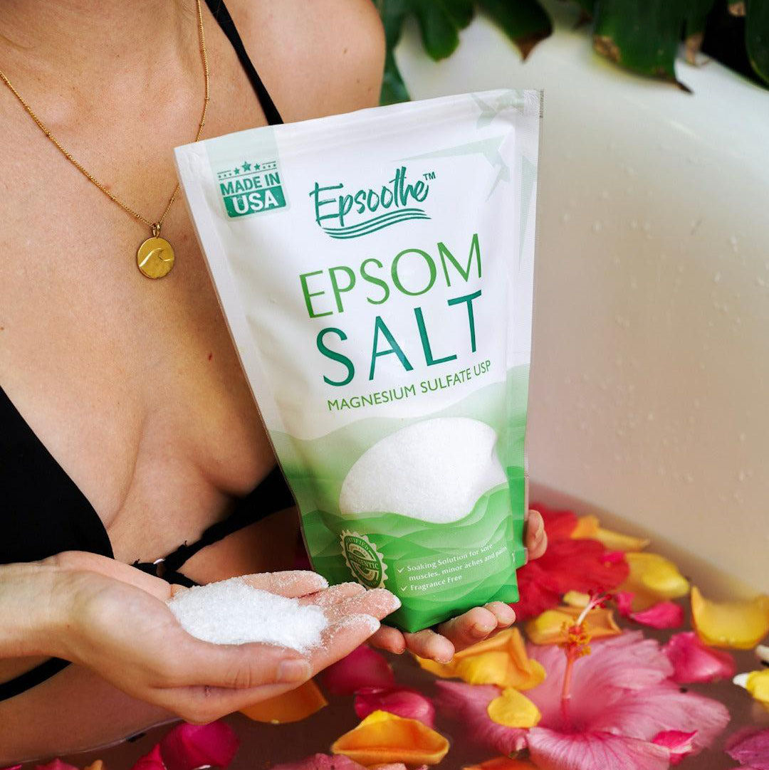 A woman holding a bag of Epsoothe Epsom Salt in a bath